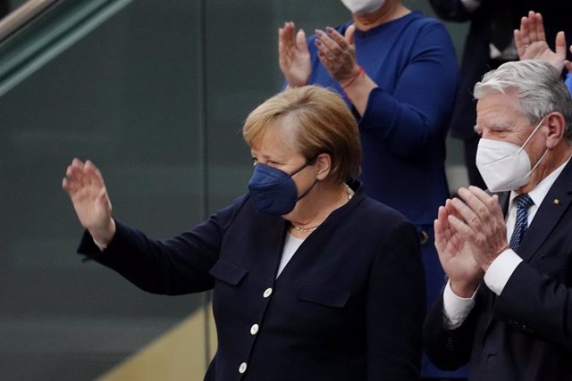 08 December 2021, Berlin: Acting German Chancellor Angela Merkel (L), attends a session of the German Bundestag, where Olaf Scholz will be elected as the new German Chancellor. Photo: Kay Nietfeld/dpa