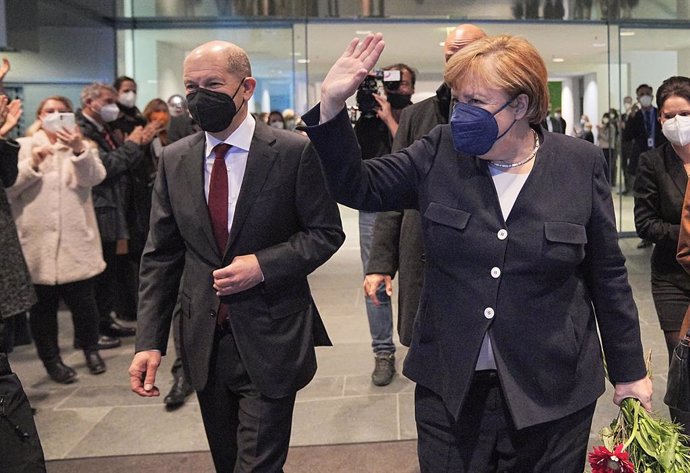 08 December 2021, Berlin: Former German Chancellor Angela Merkel waves goodbye as she leaves the Federal Chancellery, next to newly appointed Chancellor Olaf Scholz. Photo: Michael Kappeler/dpa