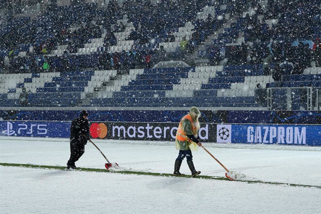 08 December 2021, Italy, Bergamo: Workers remove the snow from the pitch ahead of the UEFA Champions League Group F soccer match between Atalanta BC and Villarreal CF at Gewiss Stadium. Photo: Francesco Scaccianoce/LPS via ZUMA Press Wire/dpa