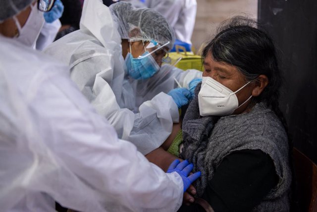 Archivo - 27 April 2021, Bolivia, La Paz: A woman with a face mask Receives the Sputnik V Coronavirus vaccine in the library room of the Universidad de San Andres. Photo: Radoslaw Czajkowski/dpa