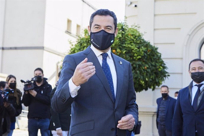 El presidente de la Junta de Andalucía, Juanma Moreno, saluda a un grupo de universitarios durante el acto de rotulación de la sede del Instituto Manuel Clavero Arévalo en la Facultad de Derecho, a 9 de diciembre de 2021 en Sevilla (Andalucía, España)