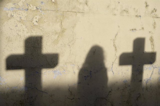 Archivo - Sombra de una mujer y dos cruces en el cementerio de San Amaro, a 21 de octubre de 2021, A Coruña, Galicia, (España).