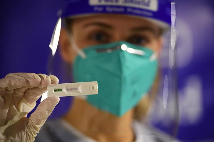 Archivo - Una sanitaria sostiene una prueba de coronavirus