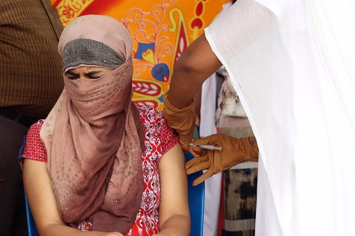 Archivo - Una mujer recibe una dosis de la vacuna contra el coronavirus en India.