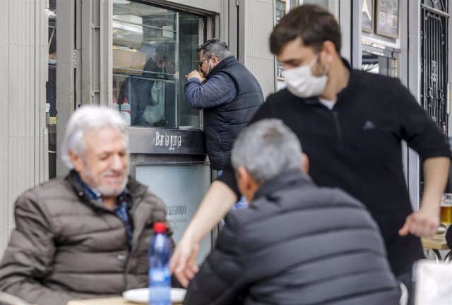 Archivo - Un camarero sirve a dos clientes en una terraza el primer día de la apertura de la hostelería en Valencia, Comunidad Valenciana (España), a 1 de marzo de 2021