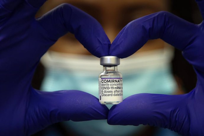 05 December 2021, United Kingdom, London: A health worker holds a vial containing Pfizer/BioNTech COVID-19 booster vaccine. People are urged to get a COVID-19 booster jab to limit the spread of the Omicron variant.
