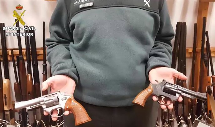 Un agente de la Guardia Civil sujeta las armas intervenidas.