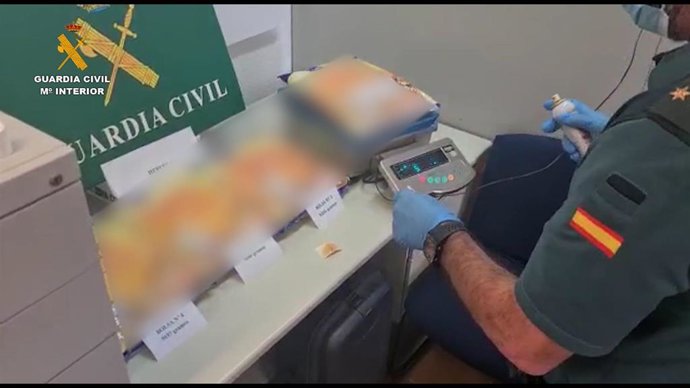 Un agente de la Guardia Civil procede al pesado de la droga intervenida