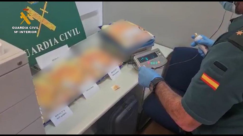 Un agente de la Guardia Civil procede al pesado de la droga intervenida