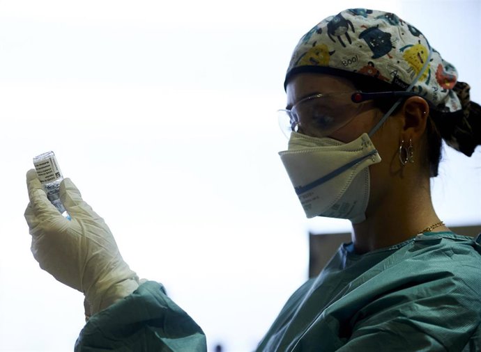 Archivo - Una profesional sanitaria sostiene un vial con la vacuna del Covid