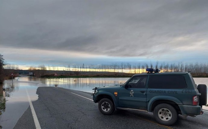 Una patrulla de la Guardia Civil ante una carretera inundada por la crecida del río
