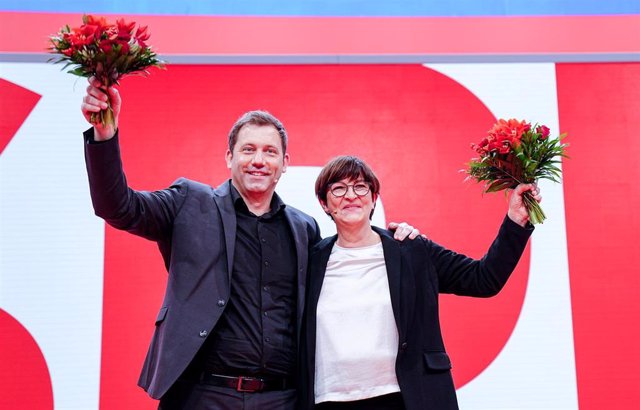 11 December 2021, Berlin: newly elected SPD party leaders Lars Klingbeil and Saskia Esken wave at their party's national convention. Photo: Kay Nietfeld/dpa