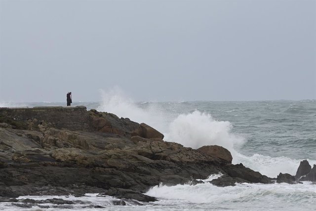 Una persona observa les ones que trenquen a la zona de les Esclaves, a 8 de desembre de 2021, a la Corunya, Galícia, (Espanya). La borrasca Barra ha fet que la Xunta hagi activat per a tot el litoral gallec una alerta taronja per temporal costaner. Segons