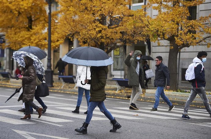 Archivo - Varias personas ccruzan un paso para peatones