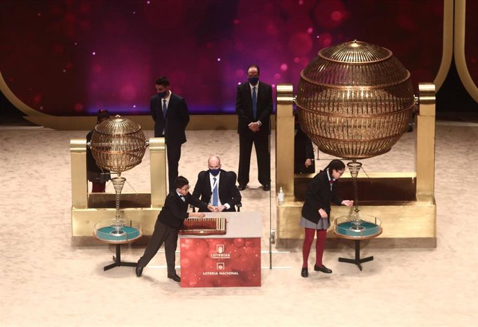 Archivo - Dos de los niños de la residencia de San Ildefonso Salvador Constantin Roaan y Noura Akrouh cantan alguno de los premios durante la celebración del Sorteo Extraordinario de la Lotería de Navidad 2020 en el Teatro Real de Madrid (España), a 22 