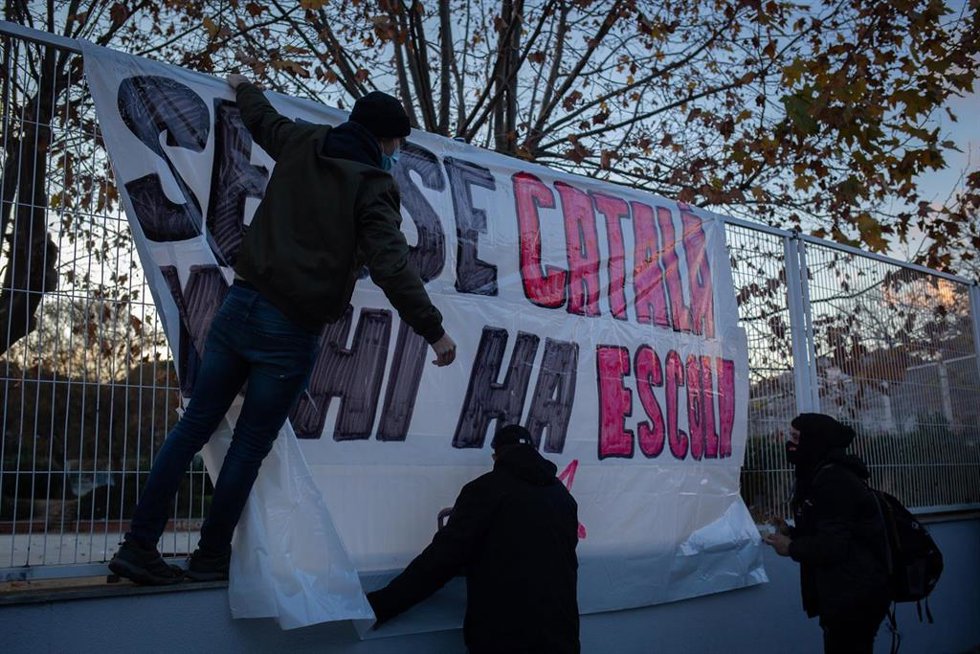 Varias personas ponen una pancarta durante una manifestación contra el establecimiento de un 25% de castellano en las escuelas catalanas, frente a la escuela Turó del Drac, a 10 de diciembre de 2021, en Canet de Mar, Barcelona, Catalunya (España). 