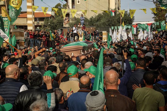 12 December 2021, Lebanon, Tyre: Mourners carry the coffin of Hamza Shahin, a Palestine engineer and a member of the Hamas Islamist organization, during his funeral outside the Burj al-Shamali Palestinian refugee camp in the Lebanese coastal city of Tyr