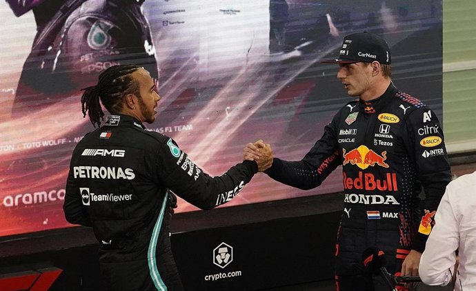 12 December 2021, United Arab Emirates, Abu Dhabi: Second-placed British Formula One driver Lewis Hamilton of Team Mercedes congratulates Dutch Formula One driver Max Verstappen of Team Red Bull after winning the Abu Dhabi Formula One Grand Prix at the 