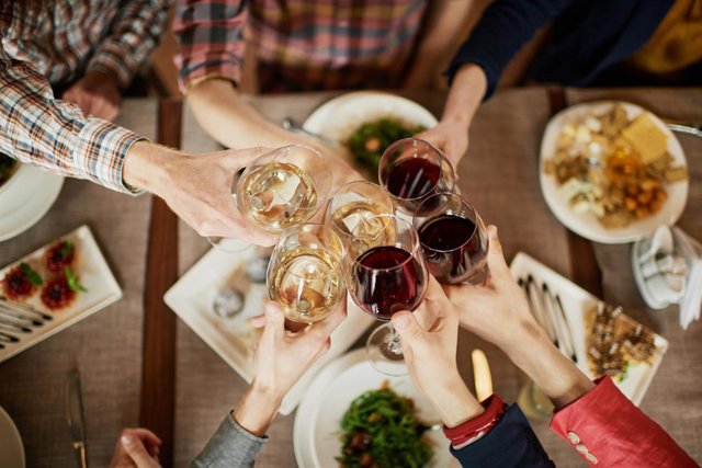 Varias personas brindan durante una cena