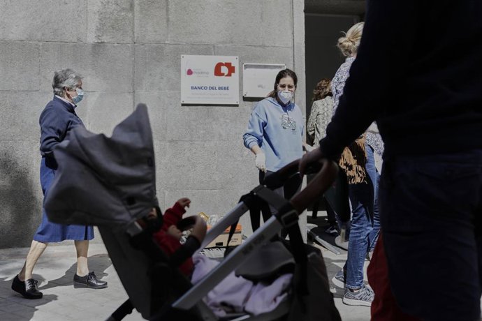 Archivo - Mujeres con carritos de bebé esperan en las inmediaciones de la Parroquia Santa María Micaela y San Enrique para recibir alimentos.