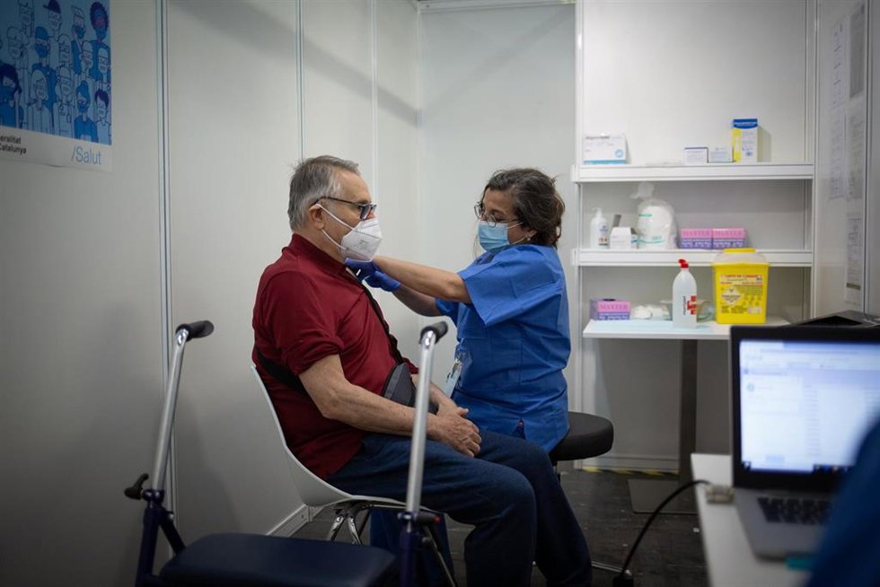 Archivo - Una sanitaria vacuna a un hombre en una imagen de archivo.