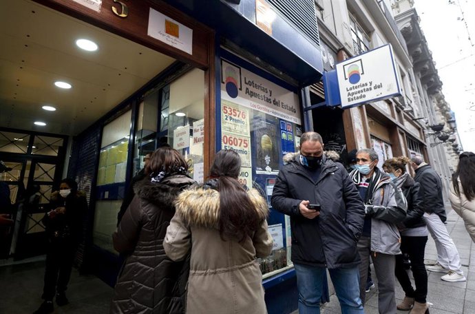 Varias personas hacen cola en una administración de Loterías del centro de Madrid. 