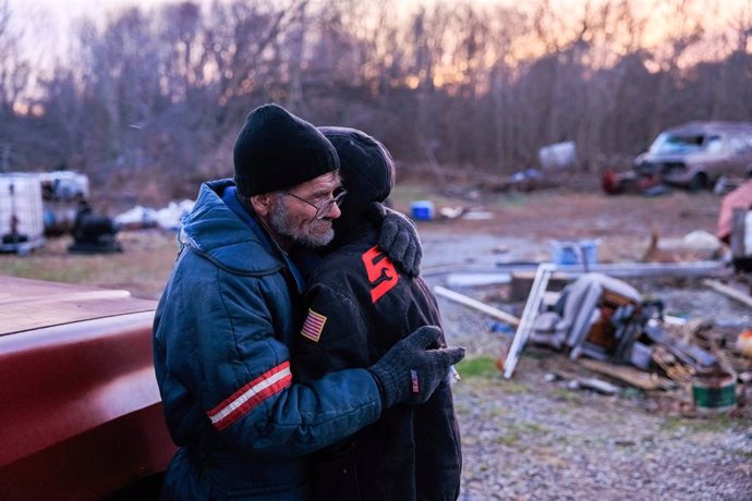 11 December 2021, US, Bloomington: Danny Mensor embraces his girlfriend Shawnee Thompson outside their destroyed home after a tornado that tore through rural Kentucky. A powerful storm in the United States has wreaked havoc and left thousands without po