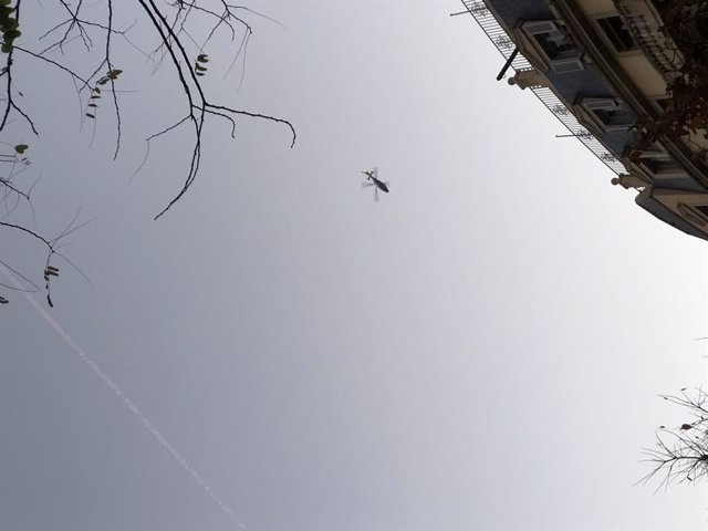 L'helicòpter vist des d'un carrer de l'Eixample de Barcelona.