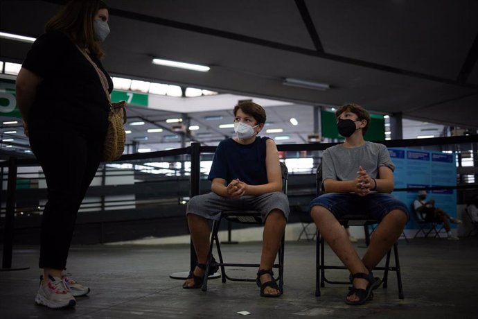 Archivo - Dos adolescentes acuden a recibir la vacuna contra el Covid-19 en el recinto de Montjuc de Fira de Barcelona, a 4 de agosto de 2021, en Barcelona, Catalunya, (España). El dispositivo, puesto en marcha este miércoles para los jóvenes de entre 