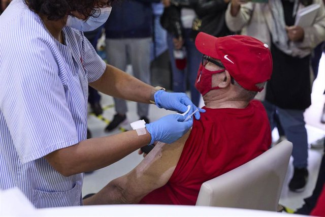 Archivo - Una sanitaria vacuna a un hombre, en la Residencia de Mayores Vista Alegre.