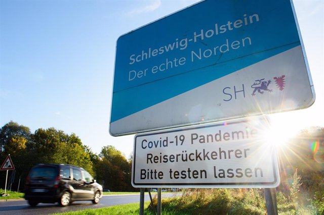 Archivo - Un cartel que reza "Pandemia de COVID19 - Viajeros que regresan - Por favor, háganse la prueba" cerca de la frontera entre Alemania y Dinamarca