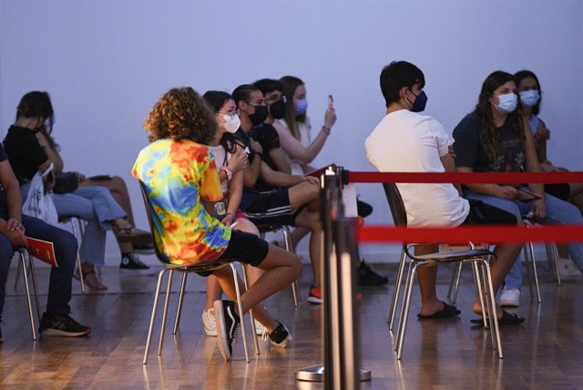 Archivo - Varios adolescentes esperan en una sala, después de recibir la primera dosis de la vacuna Pfizer en el punto de vacunación de Xátiva