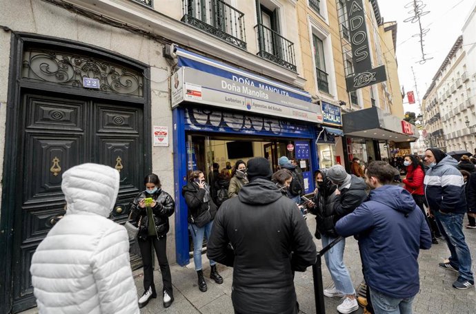 Varias personas hacen cola en la Administración de Loterías 'Doña Manolita' cuando quedan menos de tres semanas para el Sorteo Extraordinario de la Lotería de Navidad