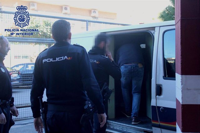 Agentes introducen el detenido con orden de búsca y captura en Italia en el furgón policial