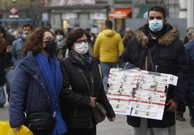 Un vendedor ambulante de lotería de Navidad cuando quedan menos de tres semanas para el Sorteo Extraordinario de la Lotería de Navidad, a 7 de diciembre de 2021, en Madrid (España). 