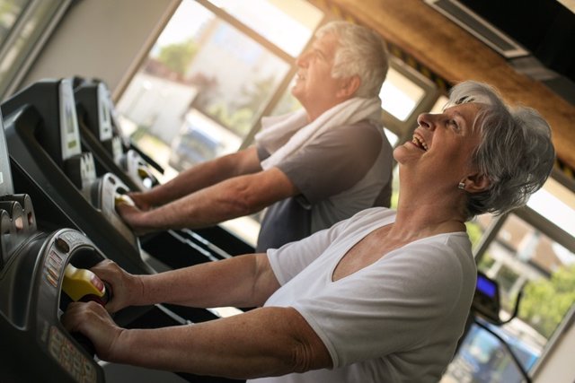 Archivo - Senior couple on jogging machine. Senior couple workout in the gym.