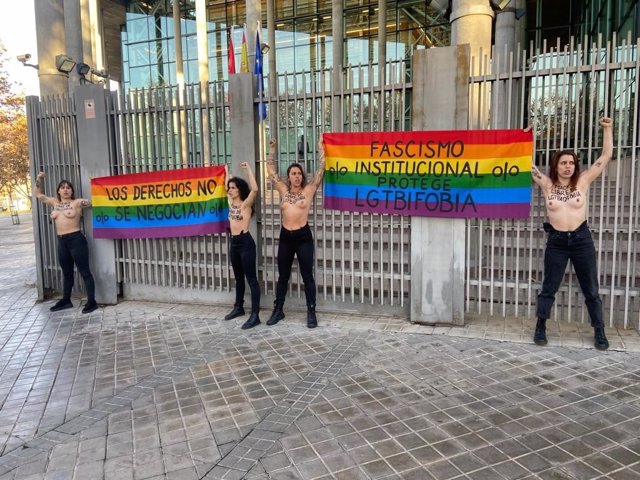 Cuatro activistas protestan a las puertas de la Asamblea de Madrid a pecho descubierto contra la derogación de leyes LGTBI