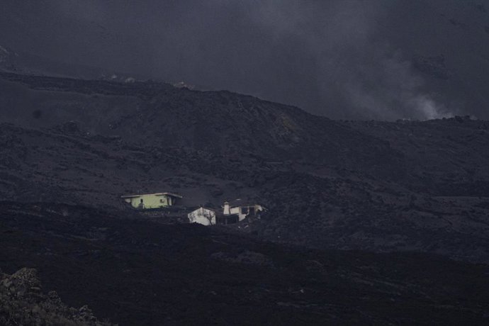 Varias viviendas semicubiertas con lava del volcán de Cumbre Vieja