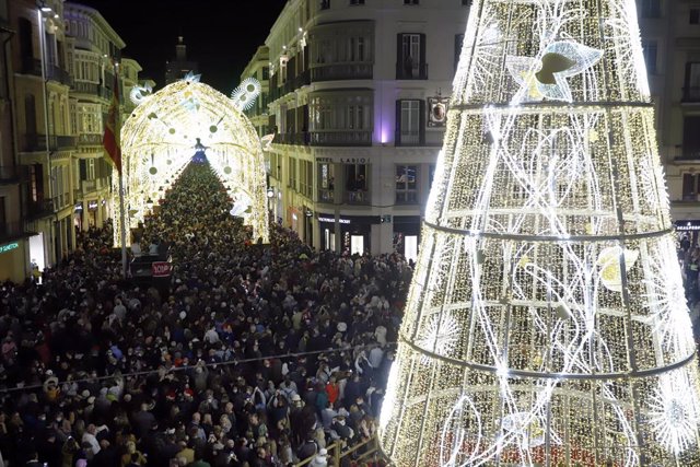 Personas disfrutan del alumbrado de Navidad en calle Larios