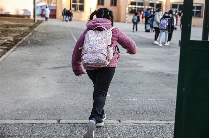 Una niña entra en un colegio
