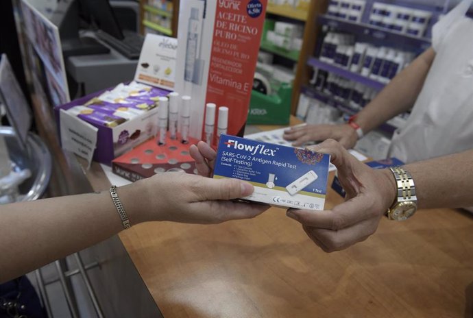 Archivo - Un farmacéutico enseña un test de antígenos de detección del COVID-19 en la farmacia situada en la Calle Tucán, 7