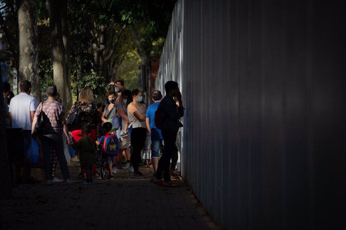 Archivo - Arxiu - Pares i alumnes esperen a la porta d'una escola