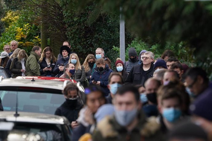 13 December 2021, United Kingdom, Sevenoaks: People queue in front of a Sevenoaks pharmacy before receiving their booster jabs. Everyone over 18 in England will be offered booster jabs as of this week, Prime Minister Boris Johnson said on Sunday night, 