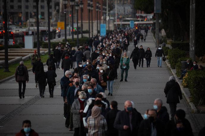 Un grupo de personas esperan a recibir la tercera dosis de la vacuna