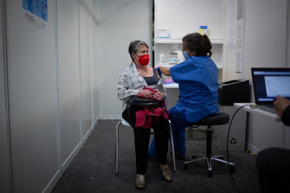 Archivo - Una sanitaria vacuna a una mujer e