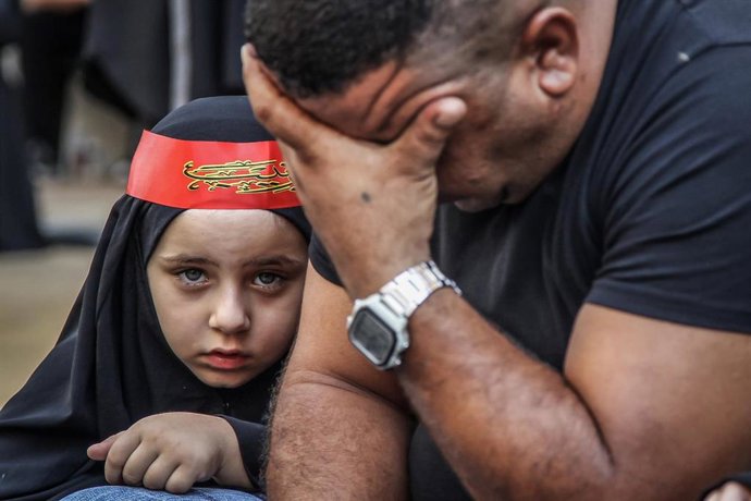 Archivo - Un padre y su hija acuden a una procesión chií en Líbano 