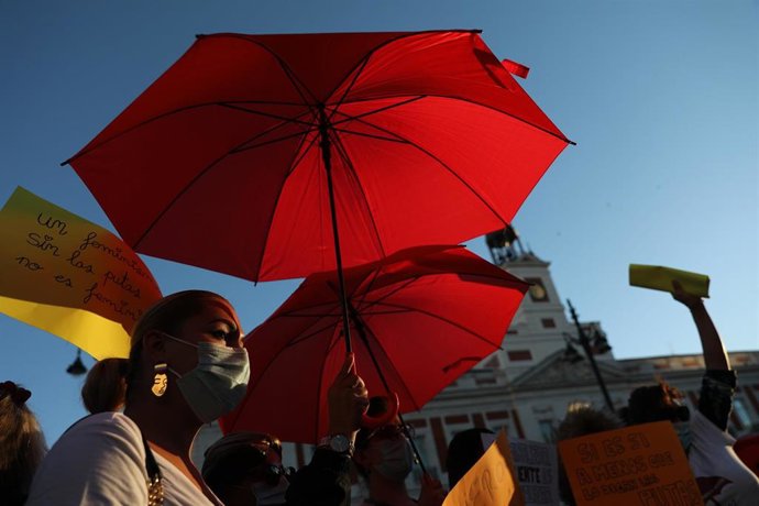 Archivo - Una trabajadora sexual con un paraguas rojo, en una foto de archivo.