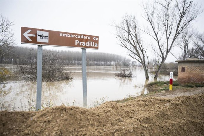 Un cartel del embarcadero de Pradilla de Ebro (Zaragoza), con la crecida extraordinaria del río de fondo.