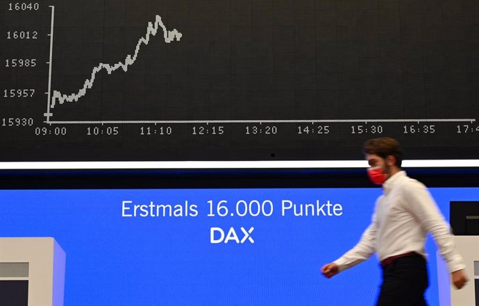 Archivo - 13 August 2021, Hessen, Frankfurt_Main: A stock exchange trader walks past a board showing the DAX Curve at the trading room of the Frankfurt Stock Exchange. DAX hit a record high of above 16,000 points for the first time ever. Photo: Arne Ded