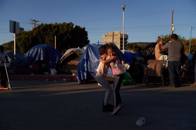 Archivo - Dos niños migrantes se abrazan en Tijuana, México